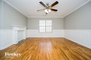 Rex house for rent - an empty living room with wood floors and a ceiling fan