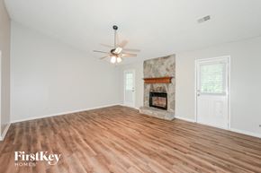 Riverdale house for rent - A spacious room with a fireplace and a ceiling fan.