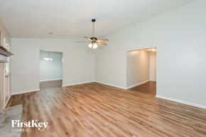 Riverdale house for rent - A room with wooden floors and a ceiling fan.