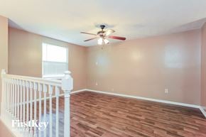 Jonesboro house for rent - a living room with a staircase and a ceiling fan