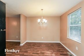 Jonesboro house for rent - a empty dining room with a wood floor and two windows