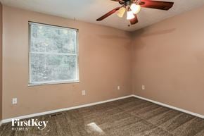 Jonesboro house for rent - an empty bedroom with a ceiling fan and a window