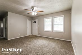 Jonesboro house for rent - A room with a carpeted floor and a ceiling fan.
