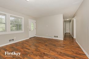 Riverdale house for rent - the living room and hallway of a house with wood floors
