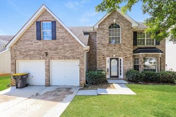 Fayetteville house for rent - a home with a white garage door and a brick house