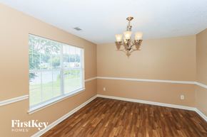 Fayetteville house for rent - the dining room of a house with wood floors and a large window