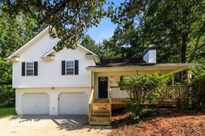 Dallas house for rent - A white house with a black roof and a brown deck.