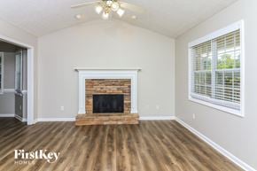 Dallas house for rent - A room with a fireplace and wooden floors.