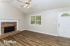 Dallas house for rent - A room with a fireplace and a ceiling fan.
