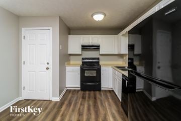 Dallas house for rent - A kitchen with a black oven and white cabinets.