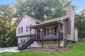 Douglasville house for rent - A house with a porch and a staircase leading to the entrance.