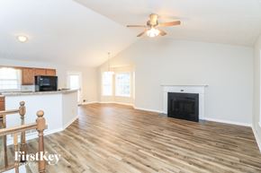 Douglasville house for rent - A spacious living room with wood flooring and a fireplace.
