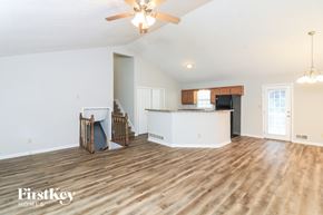 Douglasville house for rent - A spacious living room with wooden floors and a ceiling fan.