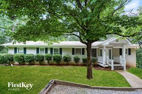 Canton house for rent - A tree in front of a white house with a porch.