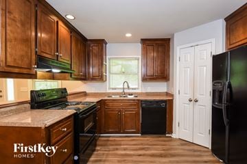 Canton house for rent - A kitchen with wooden cabinets and a black fridge.