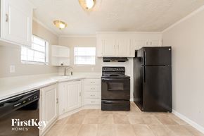Mcdonough house for rent - a kitchen with white cabinets and black appliances