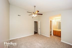 Peachtree City house for rent - A bedroom with a carpeted floor and a ceiling fan.
