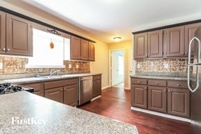 Mcdonough house for rent - a kitchen with wooden cabinets and granite counter tops