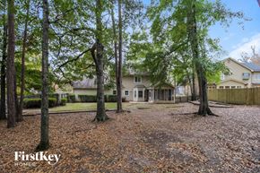 Peachtree City house for rent - a yard with trees and a house in the background