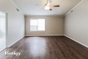 Lawrenceville house for rent - an empty living room with wood flooring and a ceiling fan