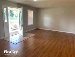 Tyrone house for rent - an empty living room with a wood floor and a door
