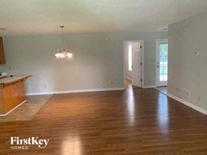Tyrone house for rent - an empty living room with wood floors and a kitchen