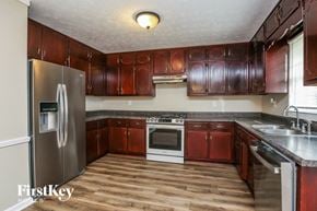 Lawrenceville house for rent - a kitchen with wooden cabinets and stainless steel appliances