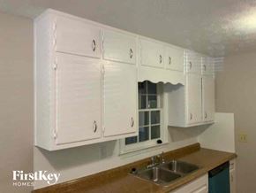 Stone Mountain house for rent - an empty kitchen with white cabinets and a sink