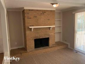 Stone Mountain house for rent - an empty living room with a brick fireplace and shelves