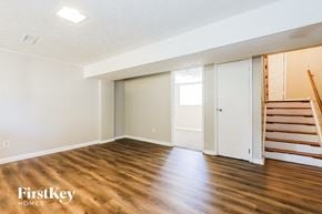 Jonesboro house for rent - A room with wooden floors and a staircase on the right side.