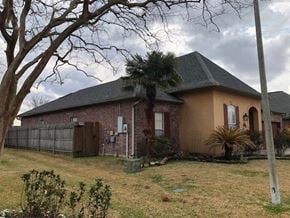 Youngsville house for rent - a brick house with a palm tree in the yard