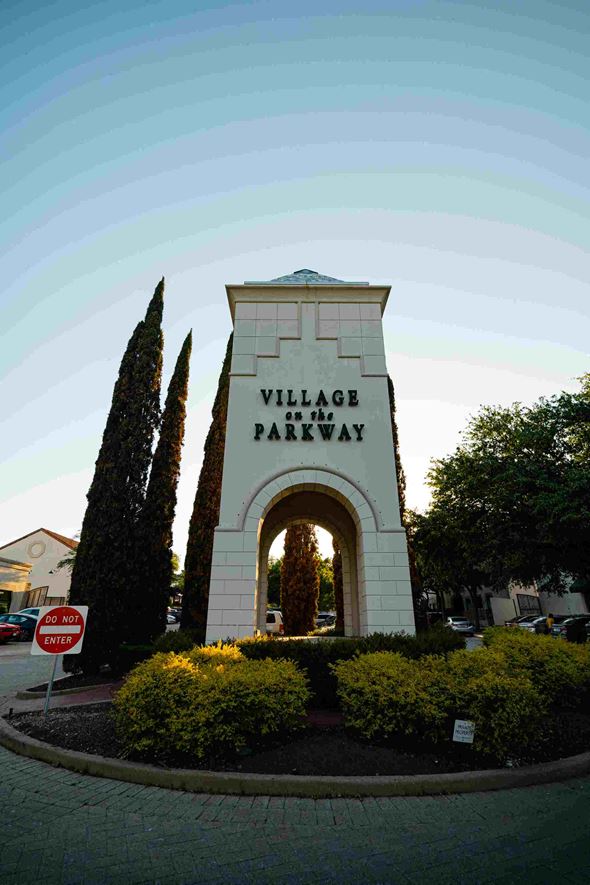Dallas apartment for rent - A sign that says "Village Parkway" is in front of some trees.