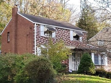 Pittsburgh house for rent - a small brick house with two windows and a yard