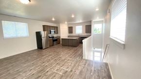 Forest Grove house for rent - A spacious living room with a kitchen area in the background.