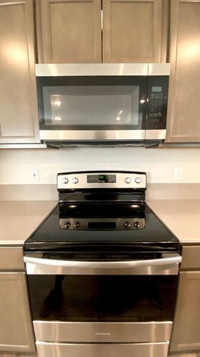 Forest Grove house for rent - A silver oven and microwave above a silver stove in a kitchen.