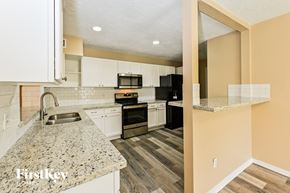 Deer Park house for rent - a kitchen with granite counter tops and white cabinets