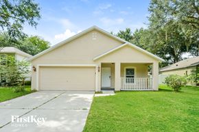 Apopka house for rent - a white house with a driveway and a lawn