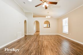 Apopka house for rent - the spacious living room with hardwood floors and a ceiling fan