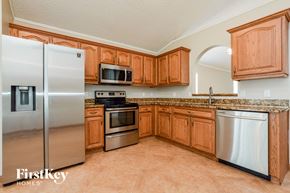 Apopka house for rent - a kitchen with wooden cabinets and stainless steel appliances