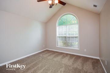 Covington house for rent - the living room of a home with an arched window and carpet