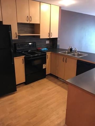 Vancouver apartment for rent - A kitchen with black appliances and wooden cabinets.