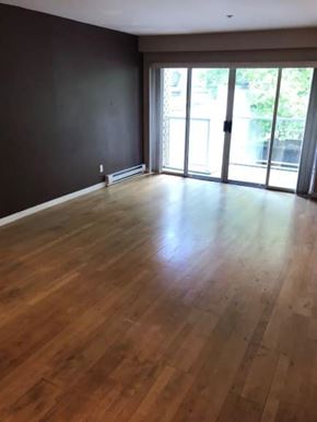 Vancouver apartment for rent - A room with wooden flooring and sliding glass doors.