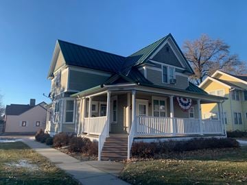 Fremont apartment for rent - A house with a green roof and a porch with a flag on it.