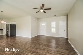 Moncks Corner house for rent - A spacious room with a ceiling fan and wooden flooring.