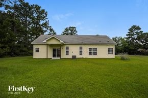 Moncks Corner house for rent - A house with a green lawn and trees in the background.