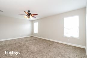 Princeton house for rent - A spacious room with a ceiling fan and two windows.