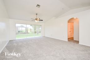 Cape Coral house for rent - A spacious room with a ceiling fan and a carpeted floor.