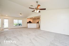 Cape Coral house for rent - A spacious room with a ceiling fan and a carpeted floor.