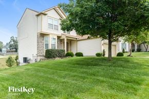 Kansas City house for rent - a home with a lawn and a tree in front of it