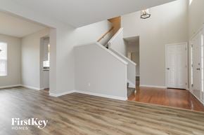 Kansas City house for rent - a renovated living room with a hardwood floor and a staircase